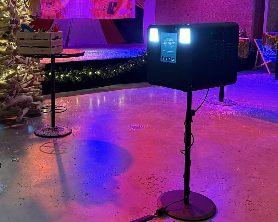 Photobooth opgesteld in een feestzaal met discobal en gekleurd licht